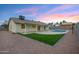Home's backyard with a pool, artificial turf, and covered patio at 6441 E Julep St, Mesa, AZ 85205