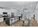 Bright open kitchen with white cabinets, black countertops, stainless steel appliances and an eat-in dining area at 6441 E Julep St, Mesa, AZ 85205