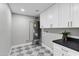 Laundry room featuring modern cabinets, sleek countertops, patterned floors, and updated fixtures at 6441 E Julep St, Mesa, AZ 85205