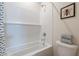 Bathroom featuring tiled bathtub with shower head, a framed art piece and towels at 670 W Laredo St, Chandler, AZ 85225