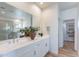 Bathroom showcasing a double vanity, a glass shower, a linen closet, and hardwood flooring at 670 W Laredo St, Chandler, AZ 85225