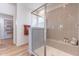 Bathroom featuring glass shower with seat, shelving, neutral tile, and a view into a walk-in closet at 670 W Laredo St, Chandler, AZ 85225