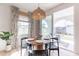 Bright dining area featuring a round wooden table, stylish light fixture, and sliding glass doors to the patio at 670 W Laredo St, Chandler, AZ 85225