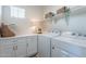 Well-lit laundry room with white cabinets, modern appliances, and decorative shelving at 670 W Laredo St, Chandler, AZ 85225