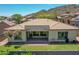Beautiful backyard with green lawn, covered patio, and charming desert landscaping at 6914 W Juana Dr, Peoria, AZ 85383
