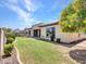 Backyard with lush landscaping, covered patio, and mature trees at 6914 W Juana Dr, Peoria, AZ 85383
