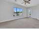 A bright carpeted bedroom with a ceiling fan and window overlooking the backyard at 6914 W Juana Dr, Peoria, AZ 85383