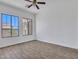 Bright bedroom with wood-look tile flooring, ceiling fan, and large windows at 6914 W Juana Dr, Peoria, AZ 85383