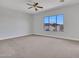A bedroom with a ceiling fan and a window overlooking the home's yard at 6914 W Juana Dr, Peoria, AZ 85383