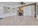 Bright living room featuring a decorative stone fireplace, ceiling fan, and modern tile flooring at 6914 W Juana Dr, Peoria, AZ 85383