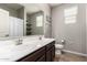 Bathroom features a dual sink vanity, a large mirror, and a window for natural light at 7216 N 124Th Ln, Glendale, AZ 85307
