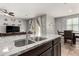 Kitchen island featuring stainless steel sink, granite countertops, and an open view of the living and dining spaces at 7216 N 124Th Ln, Glendale, AZ 85307