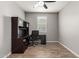 This office has wood-style flooring with a desk, chair, and wall cabinet for storage at 7216 N 124Th Ln, Glendale, AZ 85307