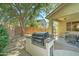 Backyard with built-in grill, covered patio, gravel landscaping, and block wall fencing at 7815 S 22Nd Ln, Phoenix, AZ 85041