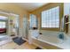 Well-lit bathroom with a soaking tub, glass-enclosed shower, and a mirrored closet at 7815 S 22Nd Ln, Phoenix, AZ 85041