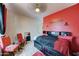 The stylish bedroom is painted red with comfortable seating at 7815 S 22Nd Ln, Phoenix, AZ 85041