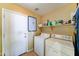 Functional laundry room with washer, dryer, shelving, and easy access to an exterior door at 7815 S 22Nd Ln, Phoenix, AZ 85041