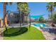 Lush backyard with trampoline, pool, and landscaping, offering a fun and inviting outdoor space for recreation and relaxation at 8307 E Buena Terra Way, Scottsdale, AZ 85250