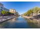 Scenic view of the canal with buildings, landscaping and a clear blue sky at 8307 E Buena Terra Way, Scottsdale, AZ 85250