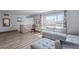 Bright living room with wood floors, large window with colorful curtains, and a comfortable sectional sofa at 8307 E Buena Terra Way, Scottsdale, AZ 85250
