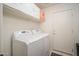 Clean laundry room with a white washer and dryer, white cabinetry, and a utility door at 835 W Beechnut Dr, Chandler, AZ 85248