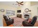 Open concept living area features a cozy fireplace, ceiling fan, and access to pool at 835 W Beechnut Dr, Chandler, AZ 85248