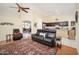 Spacious living room with leather sofa, ceiling fan, and access to the kitchen area at 835 W Beechnut Dr, Chandler, AZ 85248