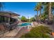 Relaxing backyard oasis with a sparkling pool, covered patio, lush landscaping, and towering palm trees at 835 W Beechnut Dr, Chandler, AZ 85248