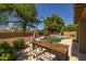 An inviting backyard with a dining table by the pool. Lush landscaping surrounds the pool and patio area at 9708 E Pampa Ave, Mesa, AZ 85212