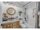 Stylish bathroom with a wood vanity, subway tile shower and decorative round mirror at 9708 E Pampa Ave, Mesa, AZ 85212