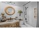 Charming bathroom with a stone sink, wood cabinets, updated light fixtures and subway tile in shower at 9708 E Pampa Ave, Mesa, AZ 85212