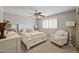 Primary bedroom with a ceiling fan, lots of natural light and a comfortable reading chair at 9708 E Pampa Ave, Mesa, AZ 85212