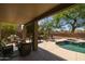 A covered patio provides a shaded retreat with comfortable seating and views of the inviting pool area at 9708 E Pampa Ave, Mesa, AZ 85212