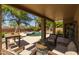 Enjoy outdoor living on the covered patio, complete with cozy seating and views of the sparkling pool at 9708 E Pampa Ave, Mesa, AZ 85212