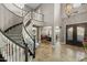 Elegant foyer features a curved staircase, decorative chandelier, and views of the adjacent dining room at 9708 E Pampa Ave, Mesa, AZ 85212