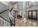 Grand entryway featuring a spiral staircase, decorative iron doors, and tile flooring leading to the dining area at 9708 E Pampa Ave, Mesa, AZ 85212