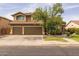 Charming two-story home boasts a three-car garage, manicured lawn, and mature shade trees at 9708 E Pampa Ave, Mesa, AZ 85212