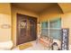 Inviting front porch with a decorative door, bench, Welcome sign, and lovely desert landscaping at 9708 E Pampa Ave, Mesa, AZ 85212