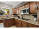 Kitchen with wood cabinets, backsplash and a window view of palm trees at 9708 E Pampa Ave, Mesa, AZ 85212