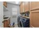 Functional laundry room with a utility sink, modern washer and dryer, and storage cabinets at 9708 E Pampa Ave, Mesa, AZ 85212