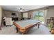 Inviting living room featuring a pool table, plush seating, and a view of the outdoor landscape at 9708 E Pampa Ave, Mesa, AZ 85212