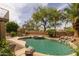 Outdoor pool and spa with rock waterfall feature, surrounded by lush landscaping at 9708 E Pampa Ave, Mesa, AZ 85212
