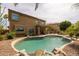 Inviting backyard pool with rock waterfall feature and covered patio area at 9708 E Pampa Ave, Mesa, AZ 85212