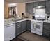 Kitchen featuring gray cabinets, white appliances, and gray and white backsplash at 10951 N 91St Ave # 255, Peoria, AZ 85345