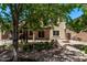 Spacious backyard featuring a tranquil pond with waterfall, mature trees, and a covered patio at 12375 W Meadowbrook Ave, Avondale, AZ 85392