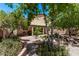 Charming backyard oasis with water feature, mature trees, patio area, and a lush landscape at 12375 W Meadowbrook Ave, Avondale, AZ 85392