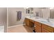 Bathroom features double sinks, wood cabinets, a large mirror, tile flooring, and neutral paint at 12375 W Meadowbrook Ave, Avondale, AZ 85392