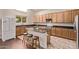 Bright kitchen offers wood cabinets, stainless appliances, a center island with seating, and a window for natural light at 12375 W Meadowbrook Ave, Avondale, AZ 85392