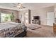 Large primary bedroom with carpeting, a TV, a ceiling fan, and a connecting en suite bath at 12375 W Meadowbrook Ave, Avondale, AZ 85392