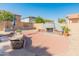 Backyard featuring a built-in BBQ and fireplace, with red brick patio. Seating and greenery at 13630 W Redfield Rd, Surprise, AZ 85379